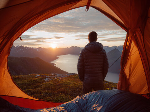 Gazing at a stunning sunset over the mountains from a tent in Alaska, embracing the beauty of nature at dusk