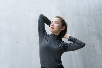 Beautiful woman puts her hands behind her head and relaxes her body