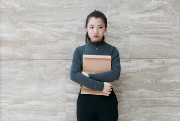 Woman holding a file bag in her arms