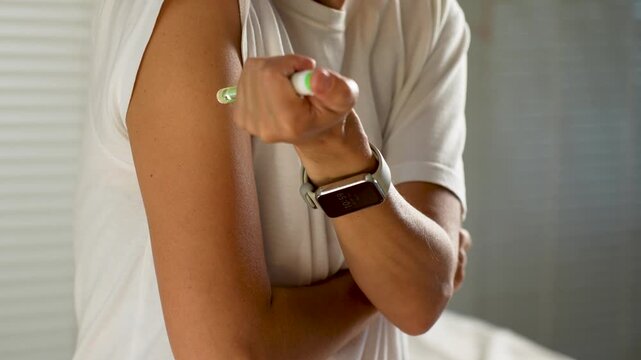 Close-up of woman hand injecting insulin pen in shoulder