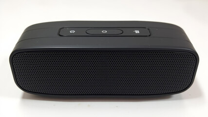 Portable speaker with surface wear and faded buttons resulting from extended use and environmental exposure
