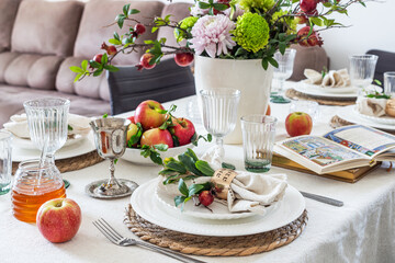 Jewish holiday Rosh Hashana festive table setting with plate, honey, apple ,book of hebrew prayers,...