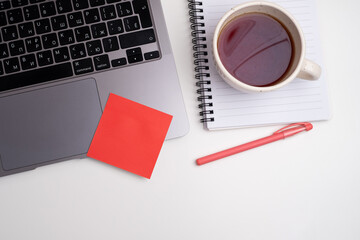 Office desk with red sticker, coffee and laptop. Office and work concept. Flat lay top view with copy space.