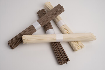 Packet of dry soba, raw buckwheat and rice noodles, uncooked buckwheat pasta, gluten free soba spaghetti on white background.