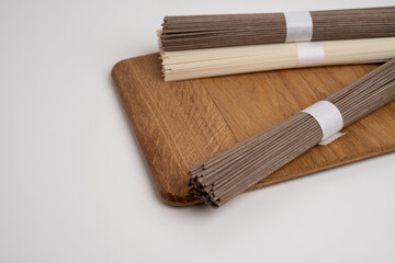 Packet of dry soba, raw buckwheat and rice noodles, uncooked buckwheat pasta, gluten free soba spaghetti on white background.