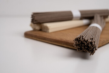 Packet of dry soba, raw buckwheat and rice noodles, uncooked buckwheat pasta, gluten free soba spaghetti on white background.