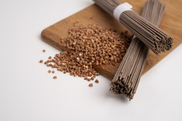 Packet of dry soba, raw buckwheat and rice noodles, uncooked buckwheat pasta, gluten free soba spaghetti on white background.