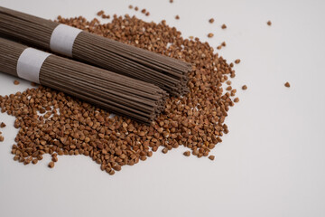 Packet of dry soba, raw buckwheat and rice noodles, uncooked buckwheat pasta, gluten free soba spaghetti on white background.