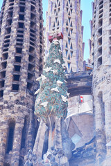 Detailed view of the Christmas tree sculpture with doves and red cross on the Sagrada Familia facade