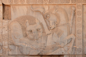 The walls of Persepolis in Iran are decorated with beautiful bas-reliefs that represent a symbol of Zoroastrianism, the eternal struggle between a bull and a lion. UNESCO World Heritage Site