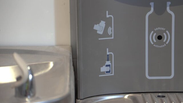 Water bottle filling station with sensor and built-in drinking fountain. Designed for convenient hydration and bottle refills.
