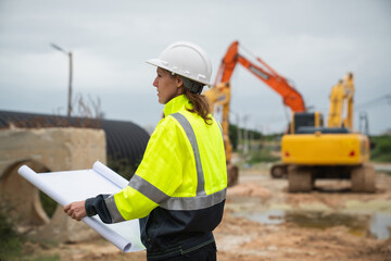 The survey team is using a theodolite and road construction plans. Civil engineers are measuring...