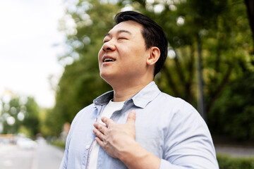 Asian man breathing fresh air in a city park