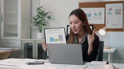 Confident Asian businesswoman delivering comprehensive financial report during virtual video conference from modern corporate office workspace - Powered by Adobe