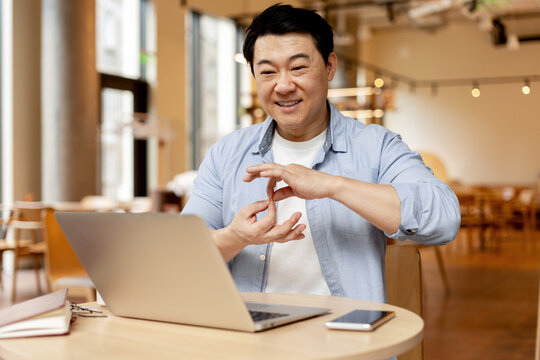 Asian businessman having video call using sign language in a cafe