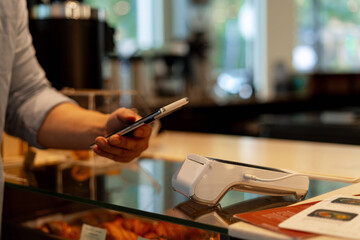 Customer paying with smartphone in a bakery using NFC technology