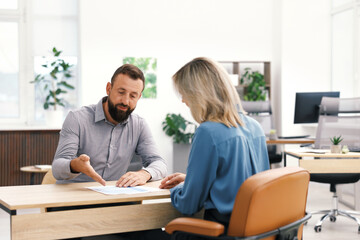 Business partners working with documents at table in office
