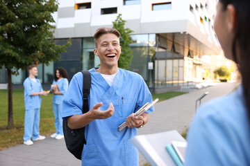 Medical students in uniforms spending time together outdoors, selective focus