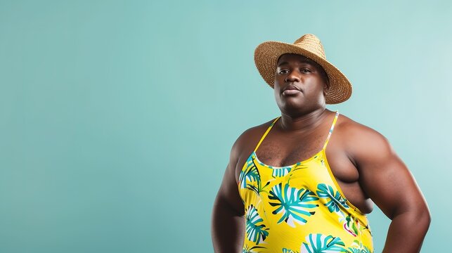 African American plus size male model wearing floral swimsuit and straw hat against teal backdrop - Powered by Adobe