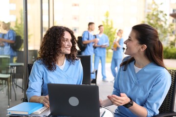 Medical students studying together in outdoor cafe, selective focus