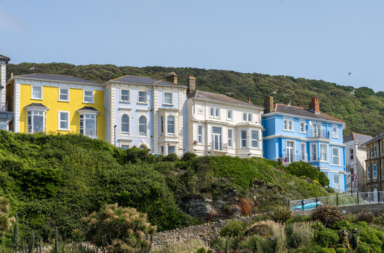 Colorful large houses, hotels or guest houses on the hillside at Ventnor on the Isle of Wight with roadway to beachfront - Powered by Adobe