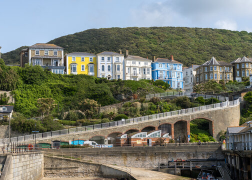 Colorful large houses, hotels or guest houses on the hillside at Ventnor on the Isle of Wight with roadway to beachfront - Powered by Adobe