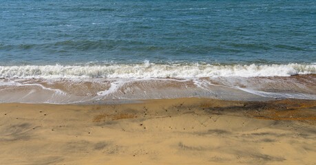 High shutter speed to freeze the motion of waves crashing onto a sandy beach on the Isle of Wight