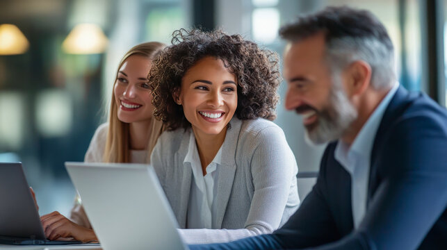 Cinematic photo of smiling professionals from various age groups collaborating around a laptop. The image showcases harmony, digital innovation, and teamwork in a modern, inclusive, and world.