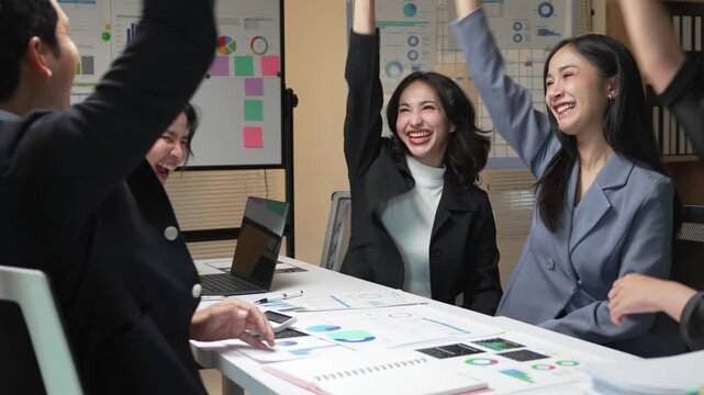 Professional team celebrating successful project milestone, sharing excitement and mutual recognition through handshakes and positive energy in corporate meeting space
