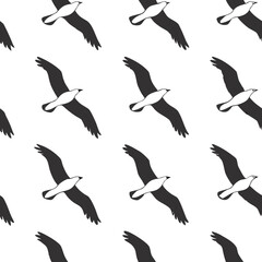 Fototapeta premium Seamless pattern of silhouette seagulls in flight against a white background
