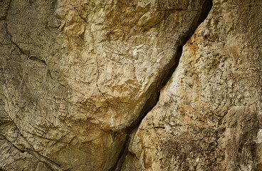 Brown stone on cave wall surface with slit for abstract background and texture. Template for design, natural patterns, space for work, banner,seamless wallpaper, close up.