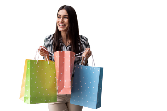 Happy woman grasping colorful shopping bags, beaming with excitement near white backdrop, expressing retail therapy triumph