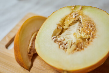 Hand-Cutting Ripe Melon on Wooden Cutting Board