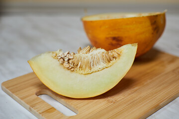 Hand-Cutting Ripe Melon on Wooden Cutting Board