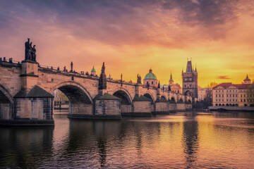 Naklejka premium Stone bridge with statues at sunset arches river