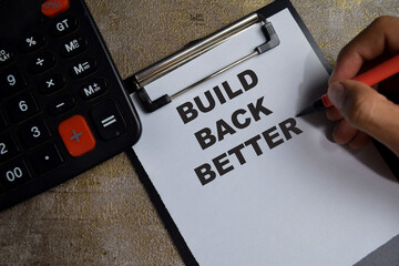 Concept of Build back better write on clipboard isolated on Wooden Table.