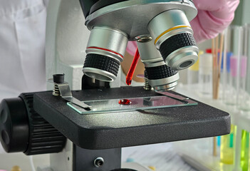 Microscope with blood sample in a laboratory setting during a scientific research experiment concept
