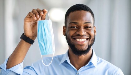 Man holding a face mask.  Happy expression