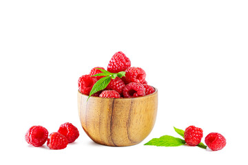Ripe shiny raspberries with leaves in a wooden bowl isolated on a white background.
