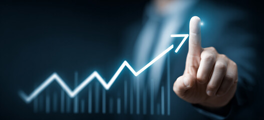 Businessman touching a glowing upward arrow graph symbolizing business growth, success, and financial progress

