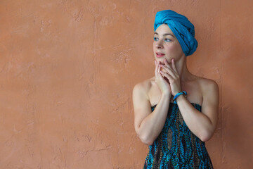 Portrait of a beautiful east woman with a turban on orange wall background.
