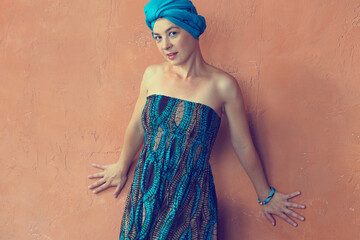 Portrait of a beautiful east woman with a turban on orange wall background.