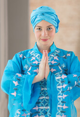 Portrait of a beautiful young woman. Woman in blue colored clothes of the east asian type.