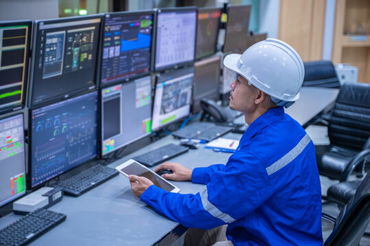 Engineer working at control room, Manager control system, Technician man monitoring program from a lot of monitor.Specialist observes analytics dashboard,operator inspects digital interface - Powered by Adobe