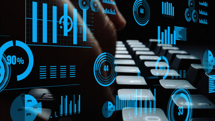 This image depicts a hand poised over a keyboard, surrounded by dynamic digital graphs and charts,...