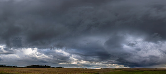 Panoramaaufnahme einer großen Regenwolke, über Getreidefeldern.