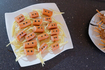 Sausage spiders with spaghetti on white plate