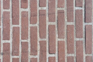 Red brick pattern. Old brick wall with cracks and scratches. Vertical wide brickwall background. Distressed wall with broken bricks texture. Vintage house facade.