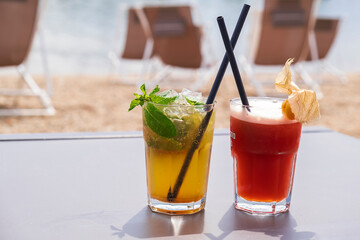 Two colorful cocktails on a table on the beach mojito and touchdown