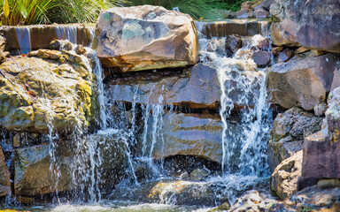 A waterfall is flowing over a rock wall